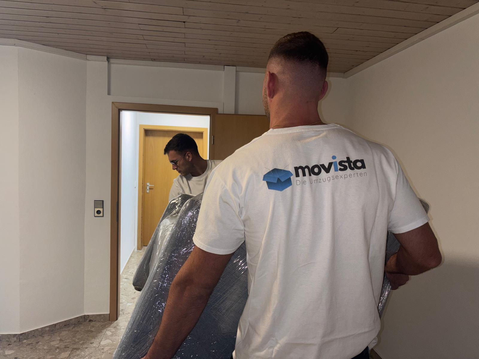Umzugshelfer von movista tragen eine eingepackte Couch bei einem Umzug in Bietigheim-Bissingen